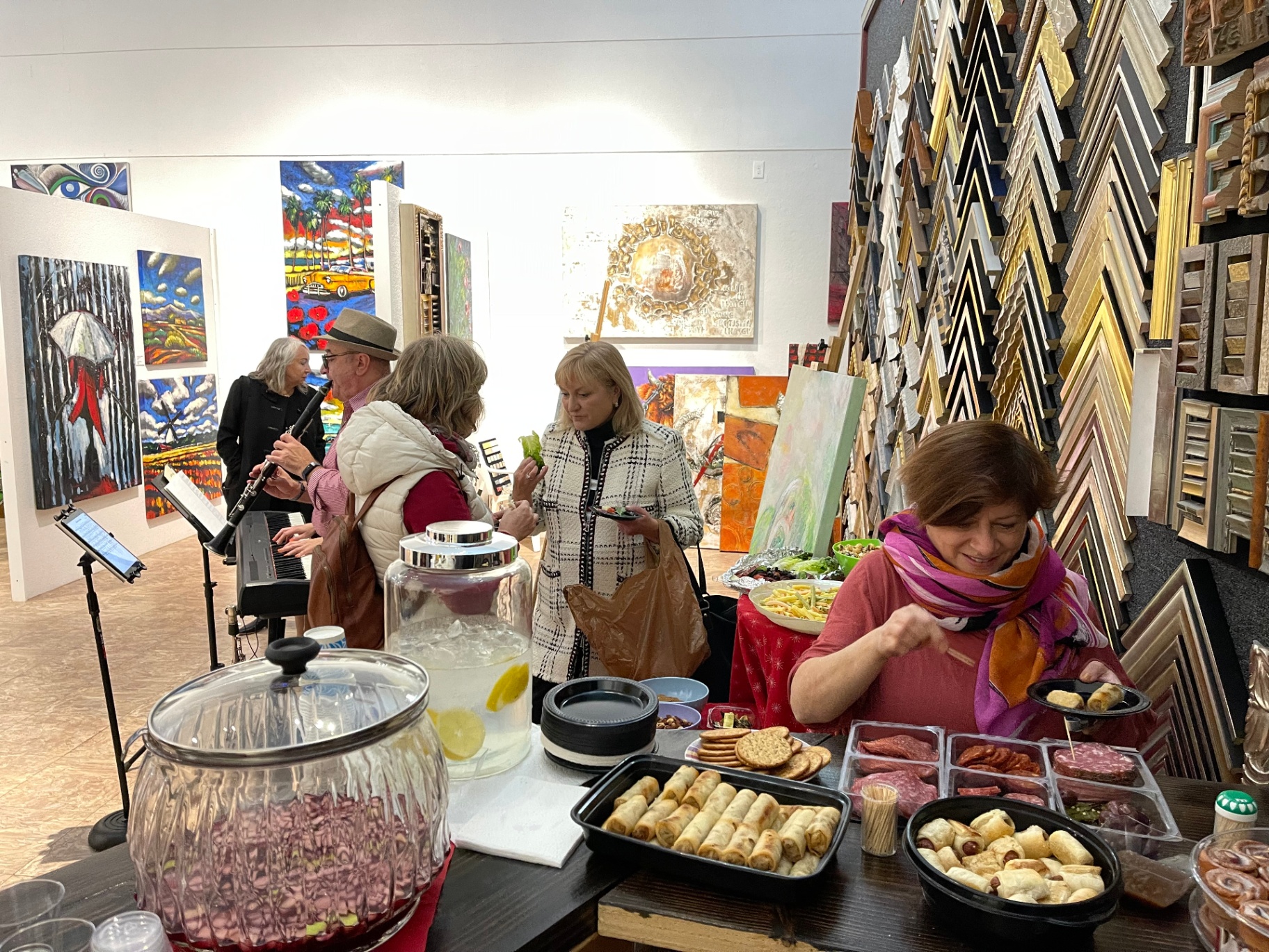 Live music and catering at an ART 2 art event with framing samples on the right.